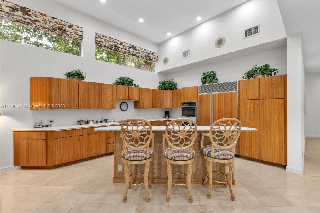 7236 Queenferry Circle Boca Raton, FL 33496 - Photo 23 of 31 a kitchen with stainless steel appliances a table and chairs