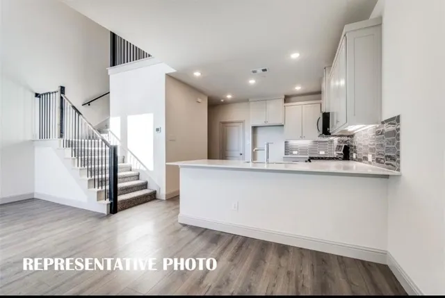 a view of kitchen with wooden floor and electronic appliances