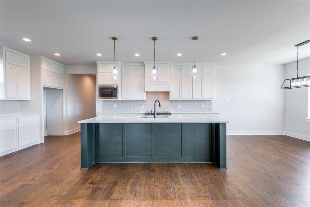 820 Evergreen Way Nevada, TX 75173 - Photo 12 of 37 a kitchen with kitchen island a sink stainless steel appliances and cabinets