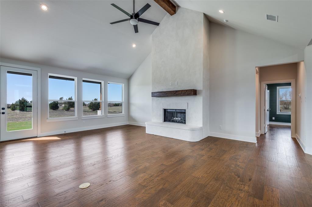 820 Evergreen Way Nevada, TX 75173 - Photo 6 of 37 an empty room with wooden floor and a fireplace