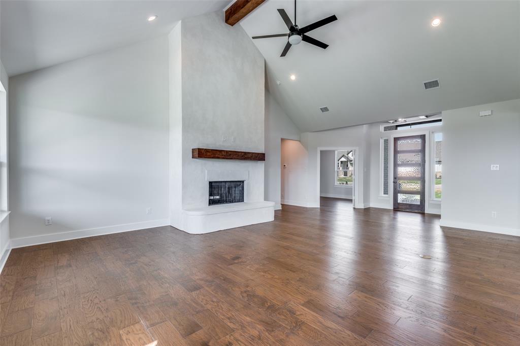 820 Evergreen Way Nevada, TX 75173 - Photo 7 of 37 an empty room with wooden floor fireplace and windows