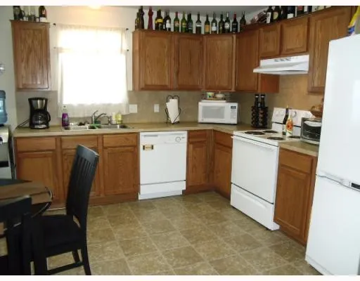 a kitchen with granite countertop a sink stove and cabinets