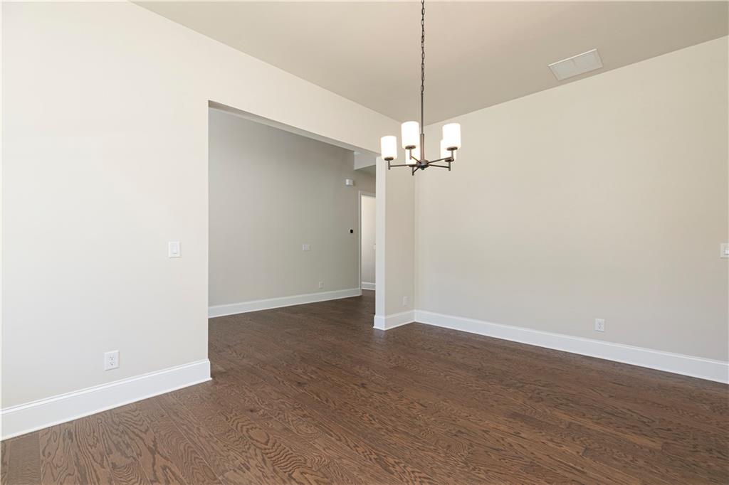 2475 Stewart Road Cumming, GA 30041 - Photo 6 of 30 an empty room with wooden floor and chandelier fan