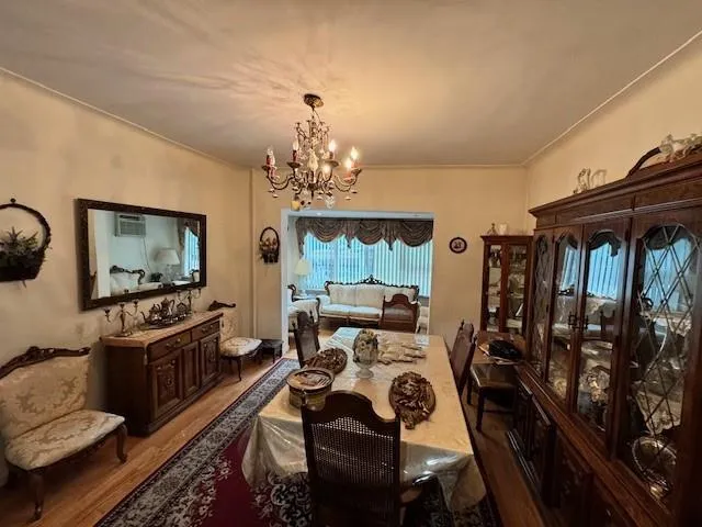 a view of a dining room with furniture a chandelier and window