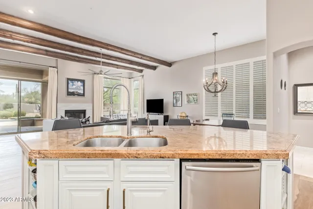 a kitchen with granite countertop kitchen island stainless steel appliances a sink and cabinets