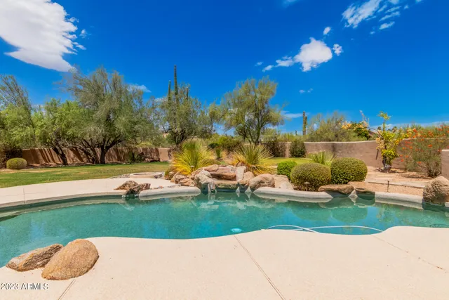 a view of a house with swimming pool and a yard