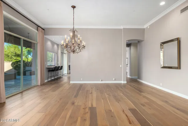 a view of a room with wooden floor potted plant and windows
