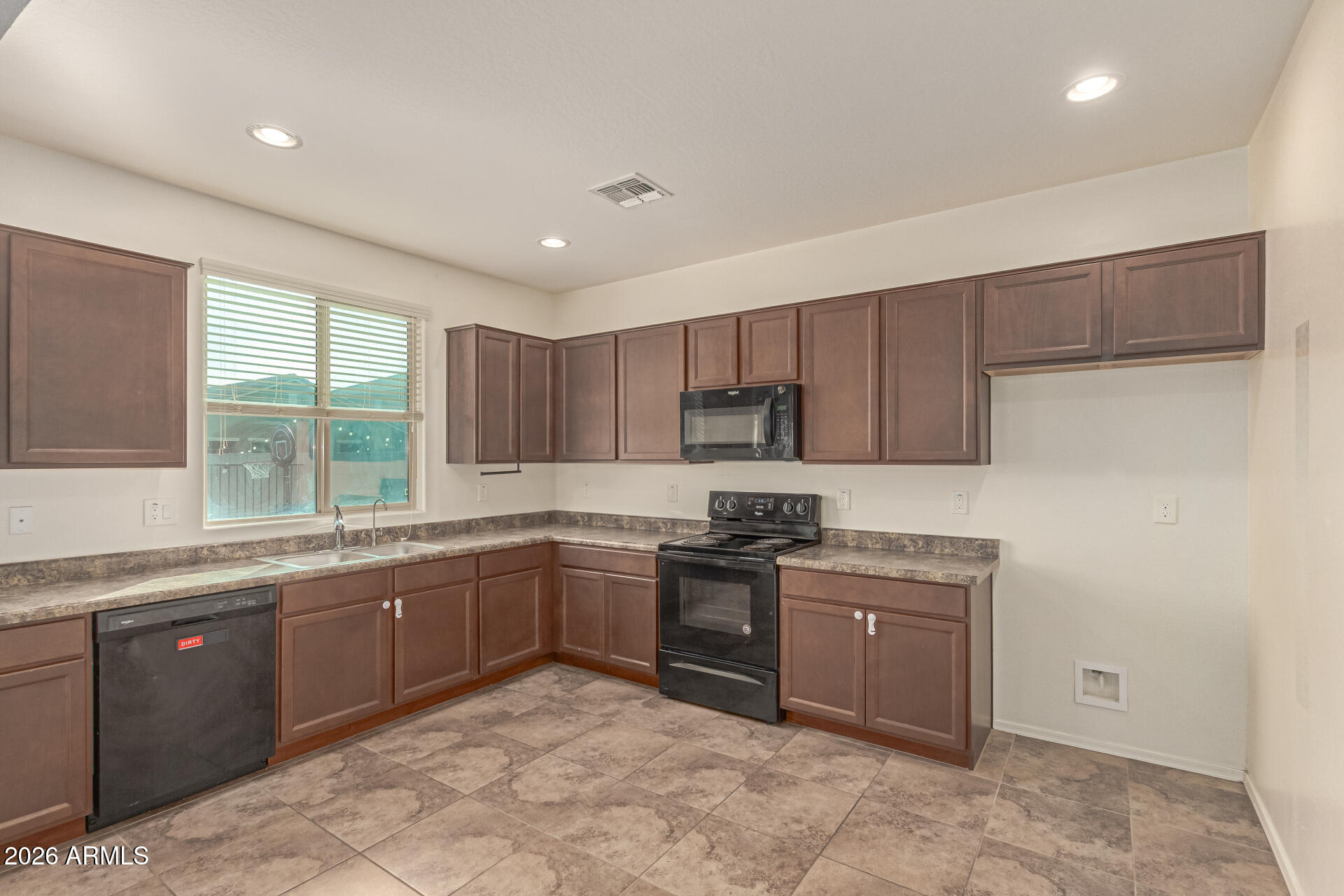 6203 West Evergreen Road Glendale, AZ 85302 - Photo 15 of 32 a kitchen with stainless steel appliances granite countertop a sink a stove and a refrigerator