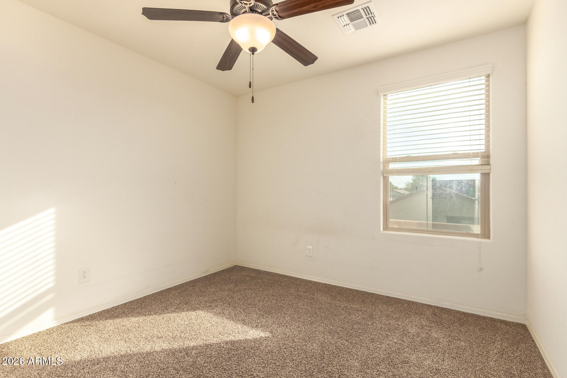 6203 West Evergreen Road Glendale, AZ 85302 - Photo 25 of 32 an empty room with a window and a fan