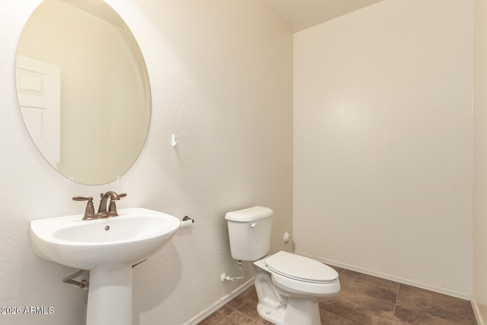 6203 West Evergreen Road Glendale, AZ 85302 - Photo 27 of 32 a bathroom with a toilet sink and mirror