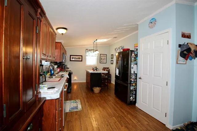 a living room with stainless steel appliances furniture and a kitchen view