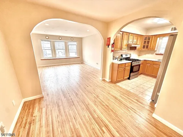 a kitchen with granite countertop a stove a sink dishwasher and cabinets with wooden floor