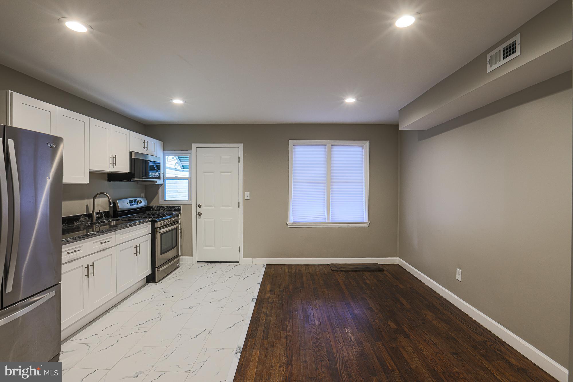 2454 Terra Firma Road Baltimore, MD 21225 - Photo 14 of 44 a kitchen with granite countertop stainless steel appliances and wooden cabinets