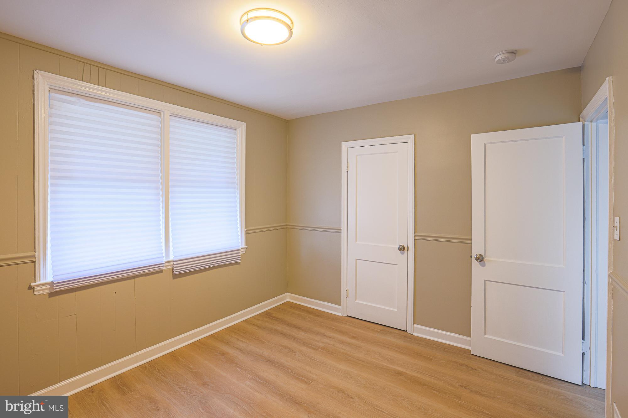 2454 Terra Firma Road Baltimore, MD 21225 - Photo 21 of 44 an empty room with wooden floor and windows