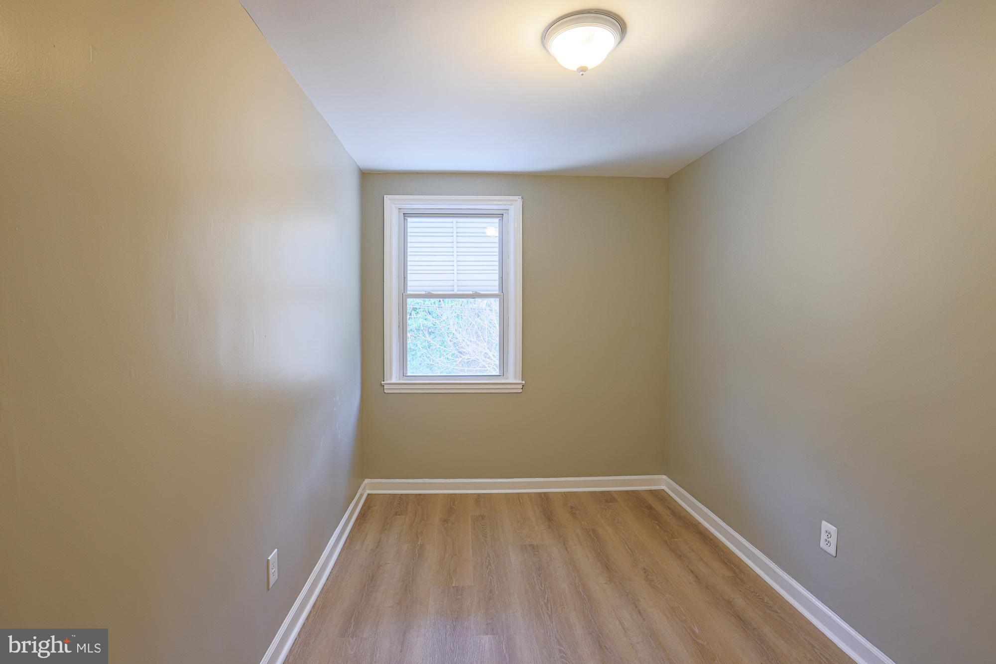 2454 Terra Firma Road Baltimore, MD 21225 - Photo 24 of 44 a view of an empty room with wooden floor and a window
