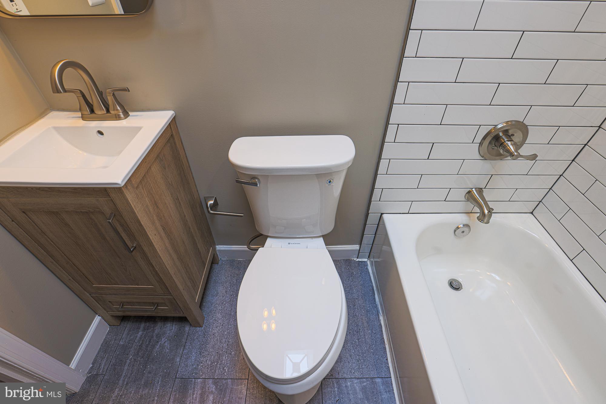 2454 Terra Firma Road Baltimore, MD 21225 - Photo 29 of 44 a bathroom with a toilet a sink and mirror