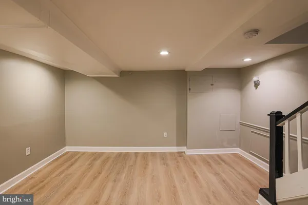 an empty room with wooden floor and entrance