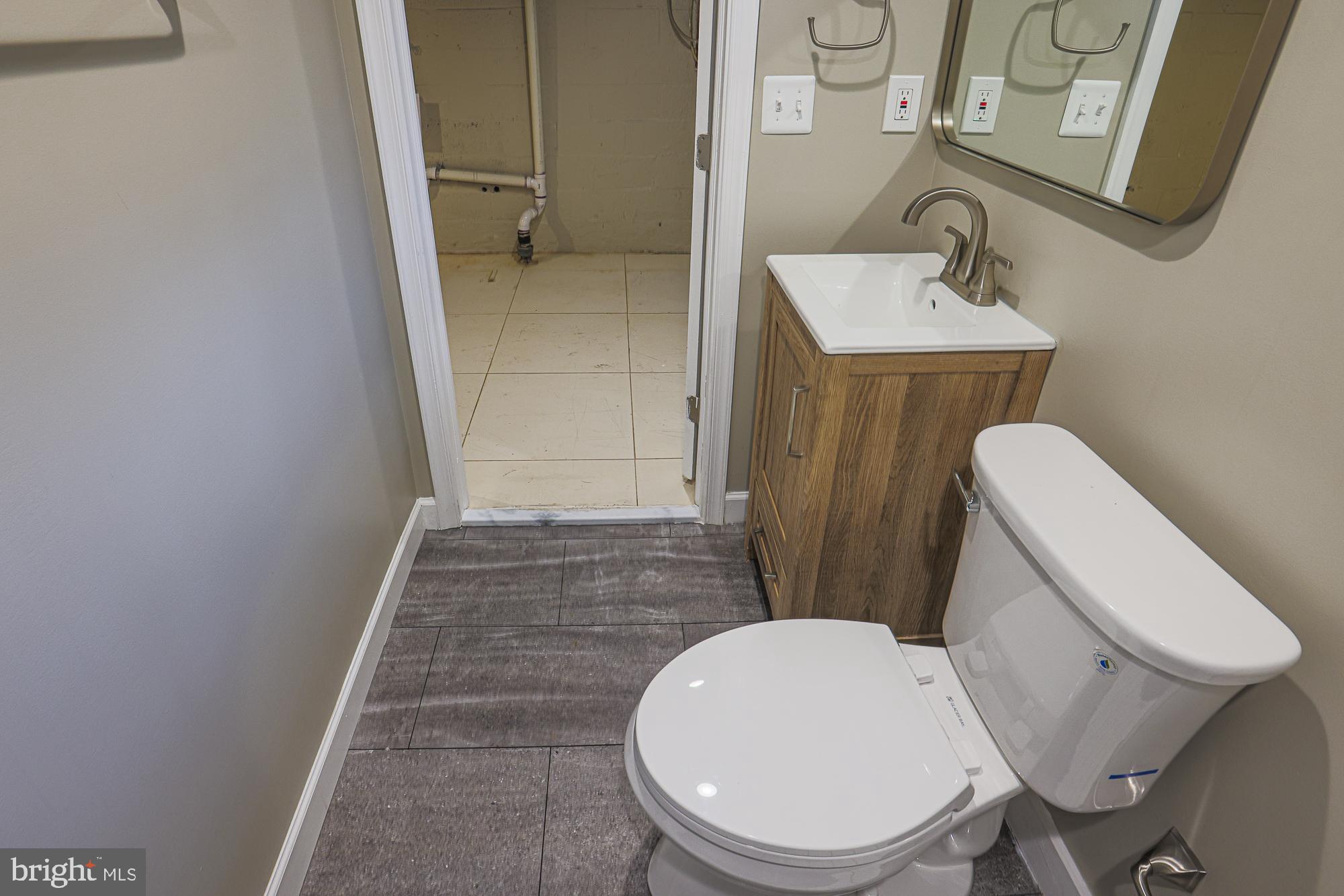 2454 Terra Firma Road Baltimore, MD 21225 - Photo 36 of 44 a white toilet sitting next to a bathroom sink