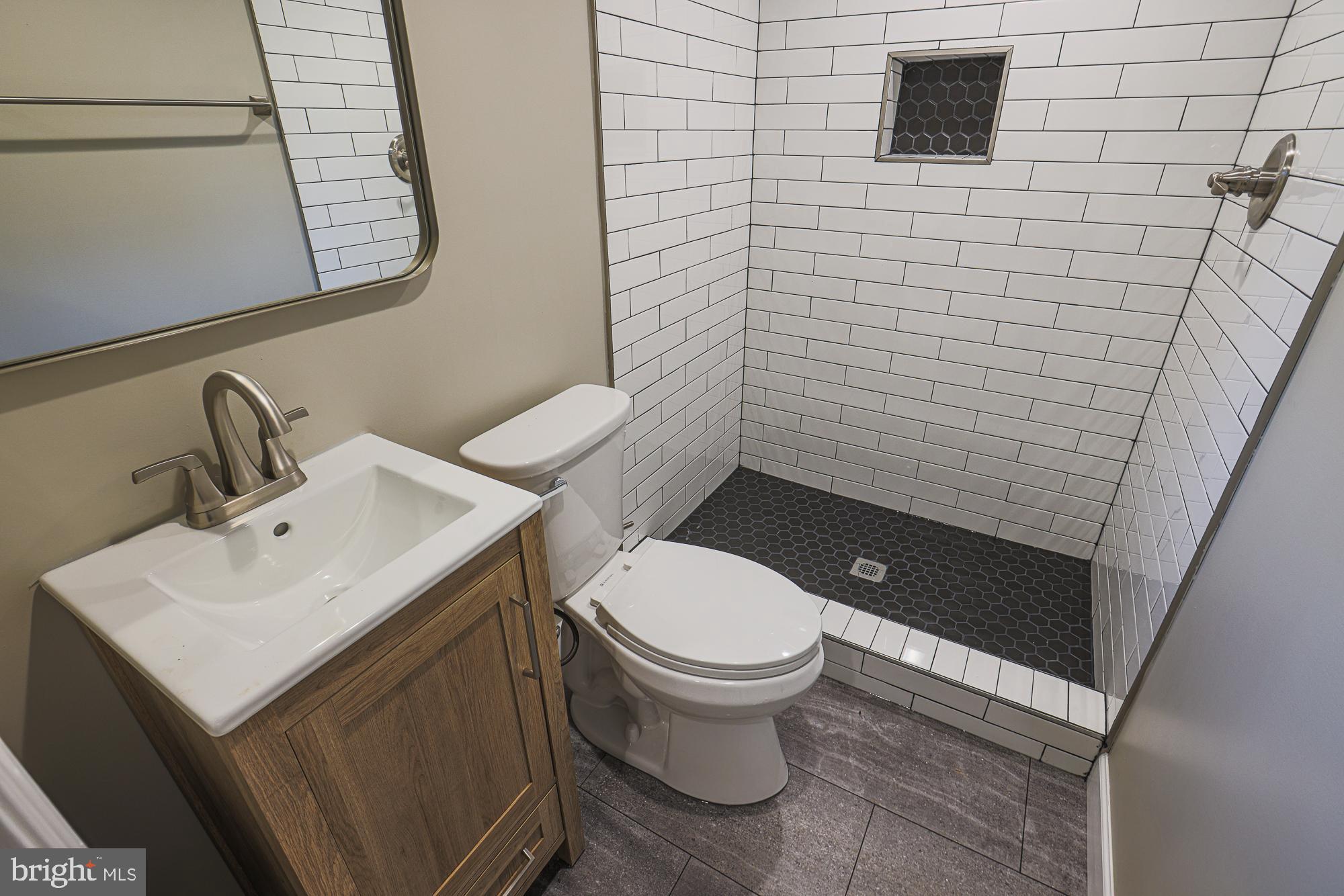 2454 Terra Firma Road Baltimore, MD 21225 - Photo 37 of 44 a bathroom with a toilet sink and mirror