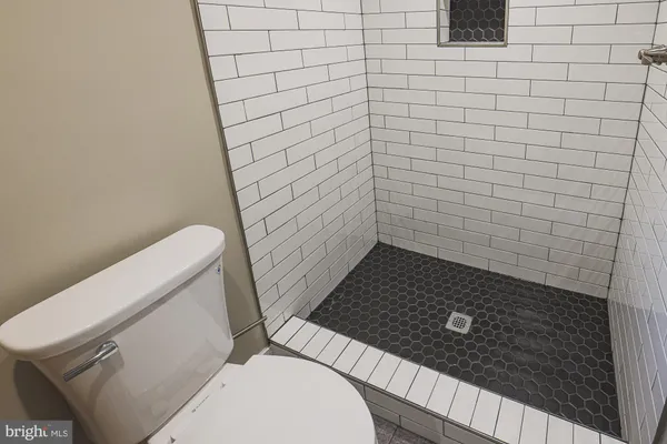 a bathroom with a granite countertop toilet and a sink