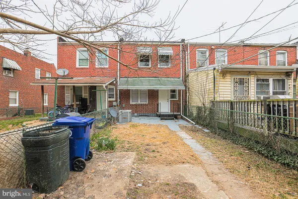 a view of a brick house with large windows and a small yard