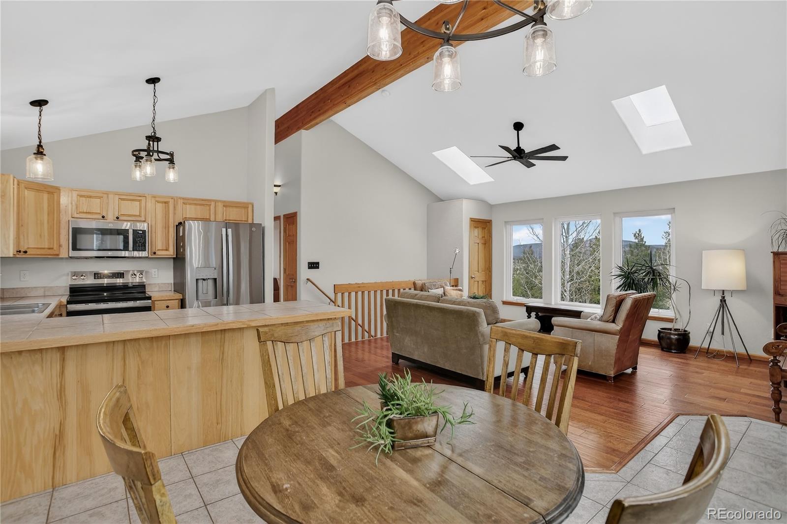 261 Mt Bailey Drive Bailey, CO 80421 - Photo 6 of 28 a living room with stainless steel appliances furniture a dining table and a chandelier