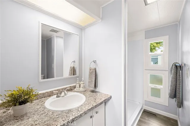 a bathroom with a granite countertop sink and a mirror