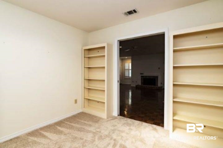 12 Stonebridge Court Mobile, AL 36608 - Photo 12 of 38 Carpeted spare room featuring baseboards and a fireplace
