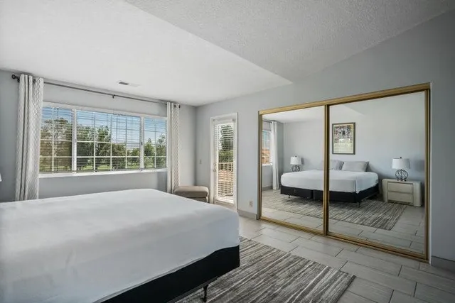 a large bedroom with a bed and large window