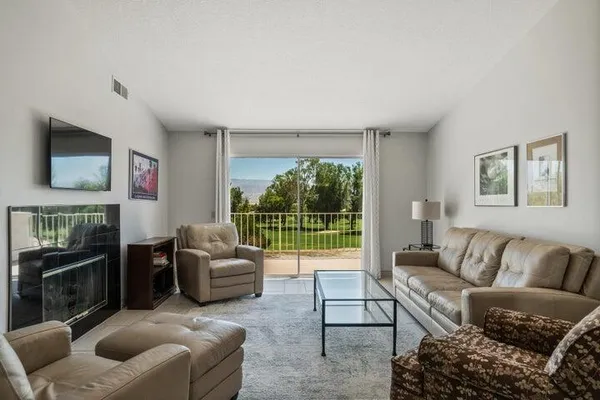 a living room with furniture and a floor to ceiling window