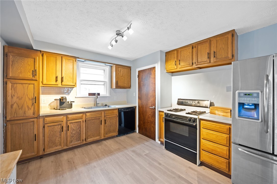 6454 Crossview Road Independence, OH 44131 - Photo 8 of 27 Kitchen featuring appliances, sink, light wood-type LVP flooring, and a textured ceiling