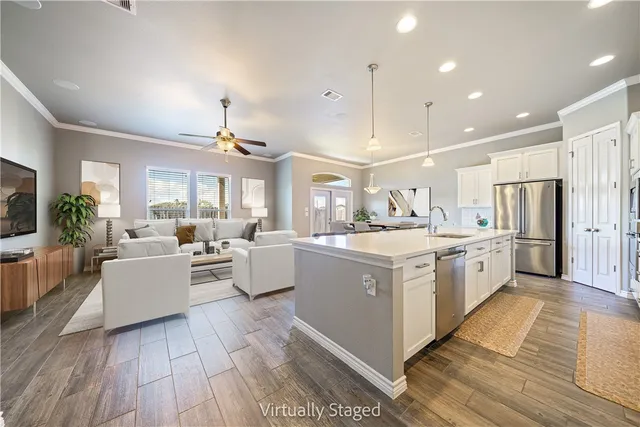 a large white kitchen with a large counter top and stainless steel appliances