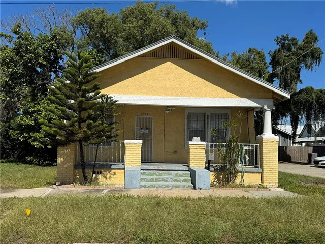 a view of a house with backyard and sitting area