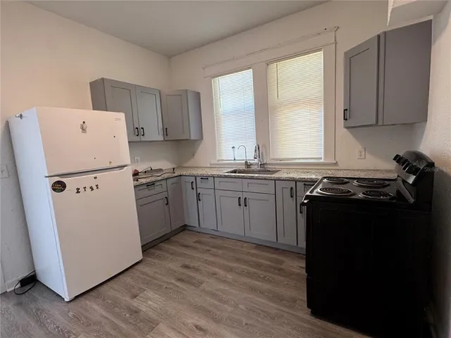 a kitchen with a refrigerator a sink and wooden cabinets