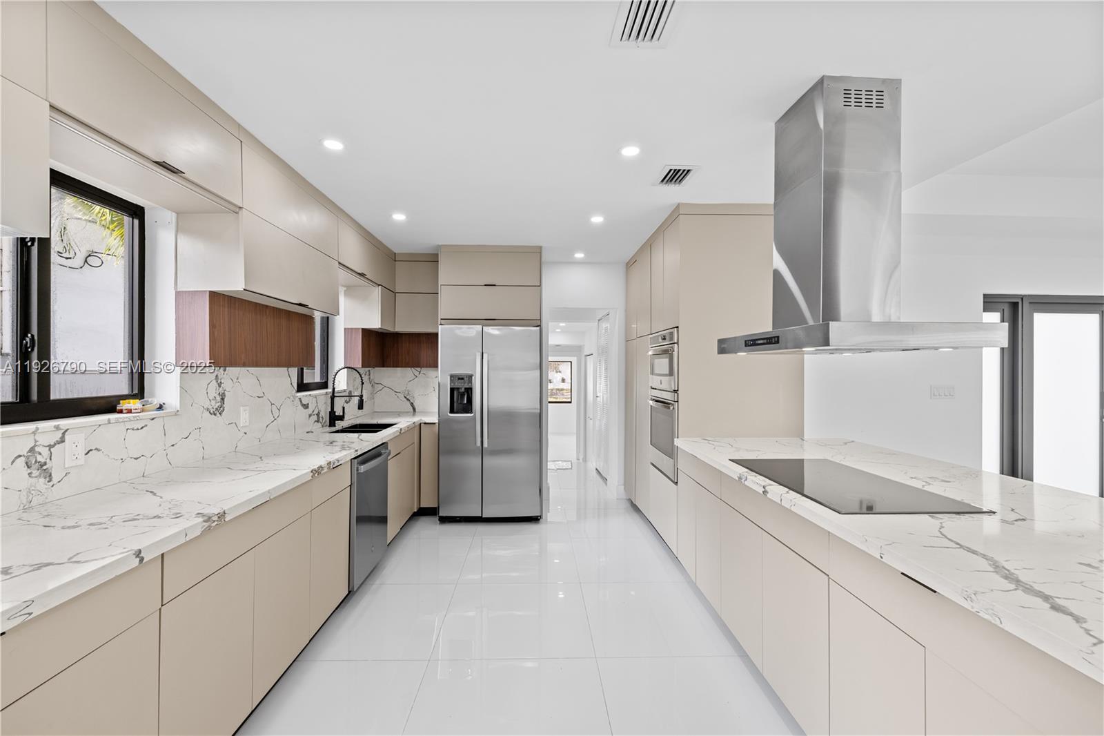 1200 Cleveland Road Miami Beach, FL 33141 - Photo 16 of 41 a large white kitchen with a large window and stainless steel appliances
