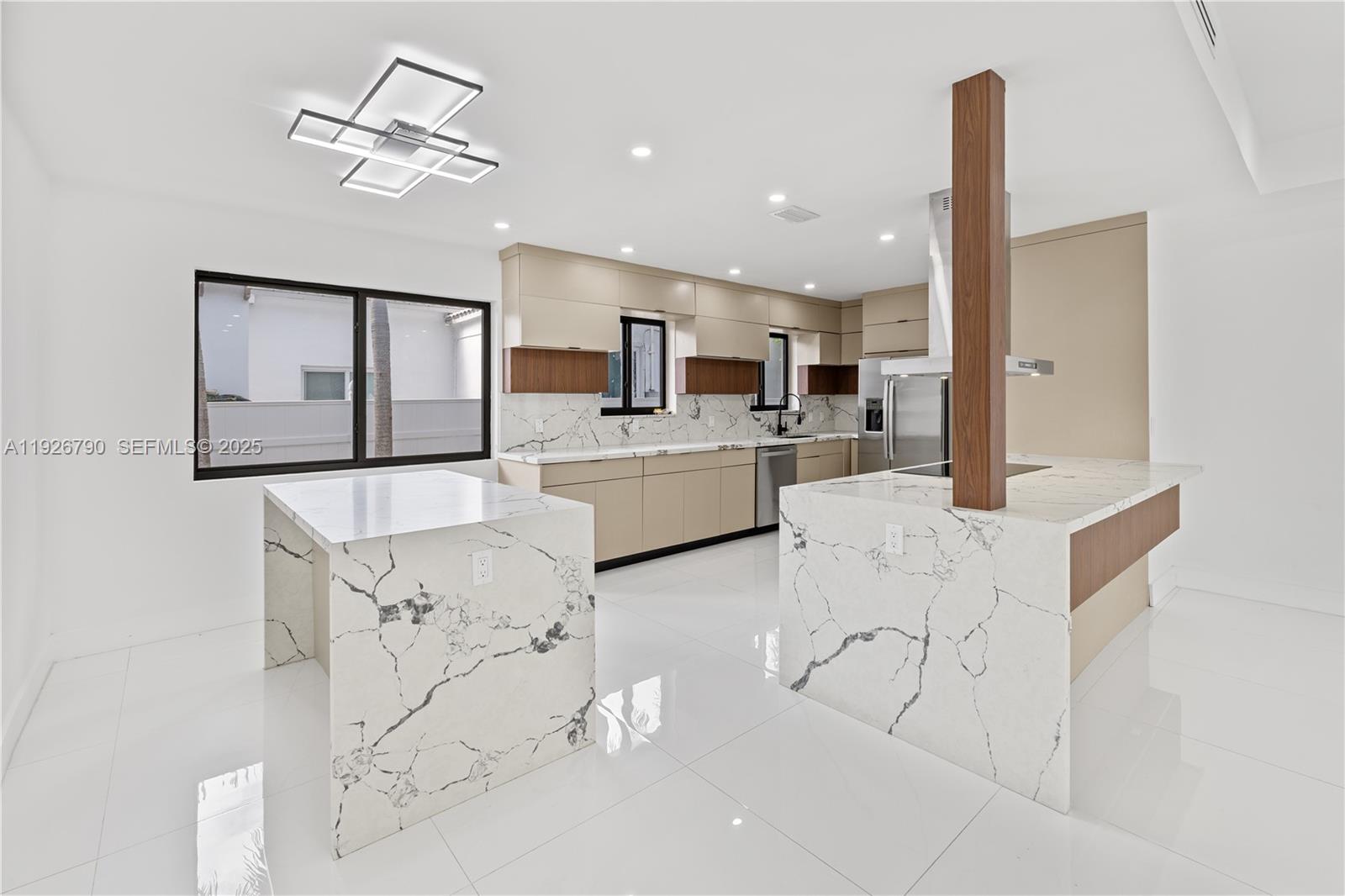 1200 Cleveland Road Miami Beach, FL 33141 - Photo 5 of 41 a kitchen with stainless steel appliances kitchen island granite countertop a refrigerator a stove a microwave oven with white cabinets and wooden floor