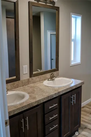 a bathroom with a granite countertop sink and a mirror
