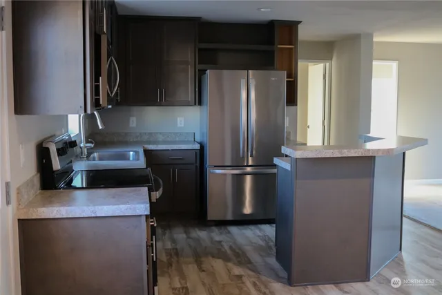 a kitchen with stainless steel appliances granite countertop a refrigerator stove and microwave