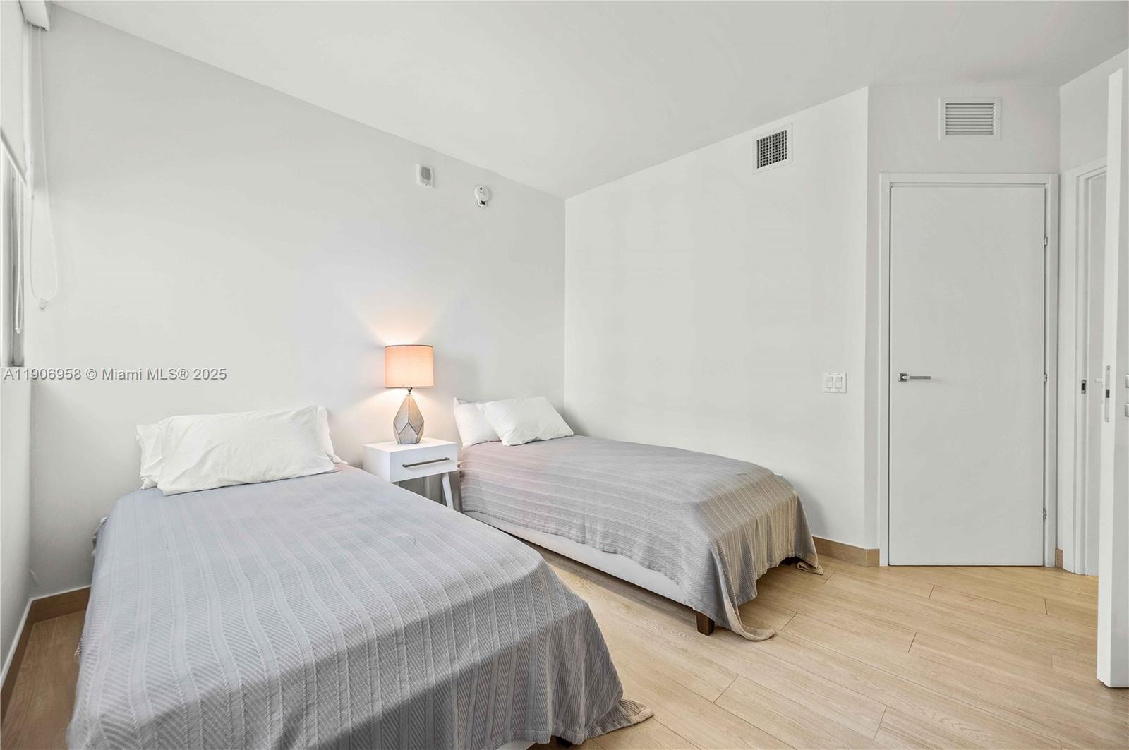 1300 Brickell Bay Drive, Unit 1603 Miami, FL 33131 - Photo 11 of 17 a bedroom with two beds and painted walls