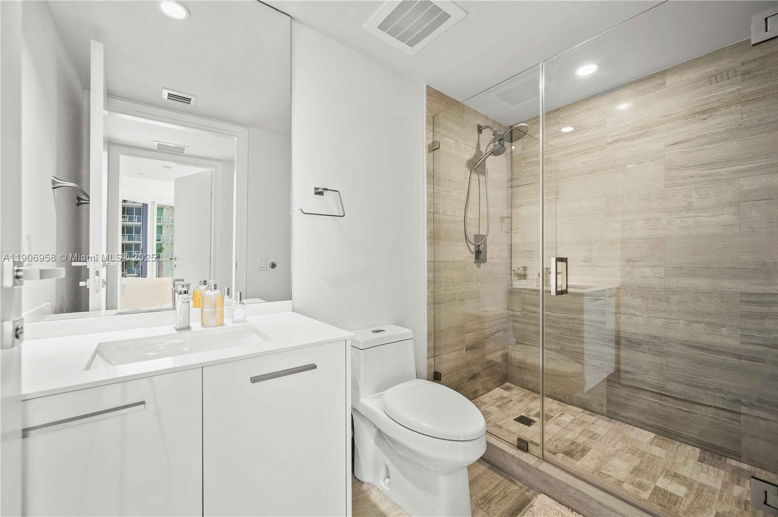 1300 Brickell Bay Drive, Unit 1603 Miami, FL 33131 - Photo 12 of 17 a bathroom with a sink toilet a mirror and shower