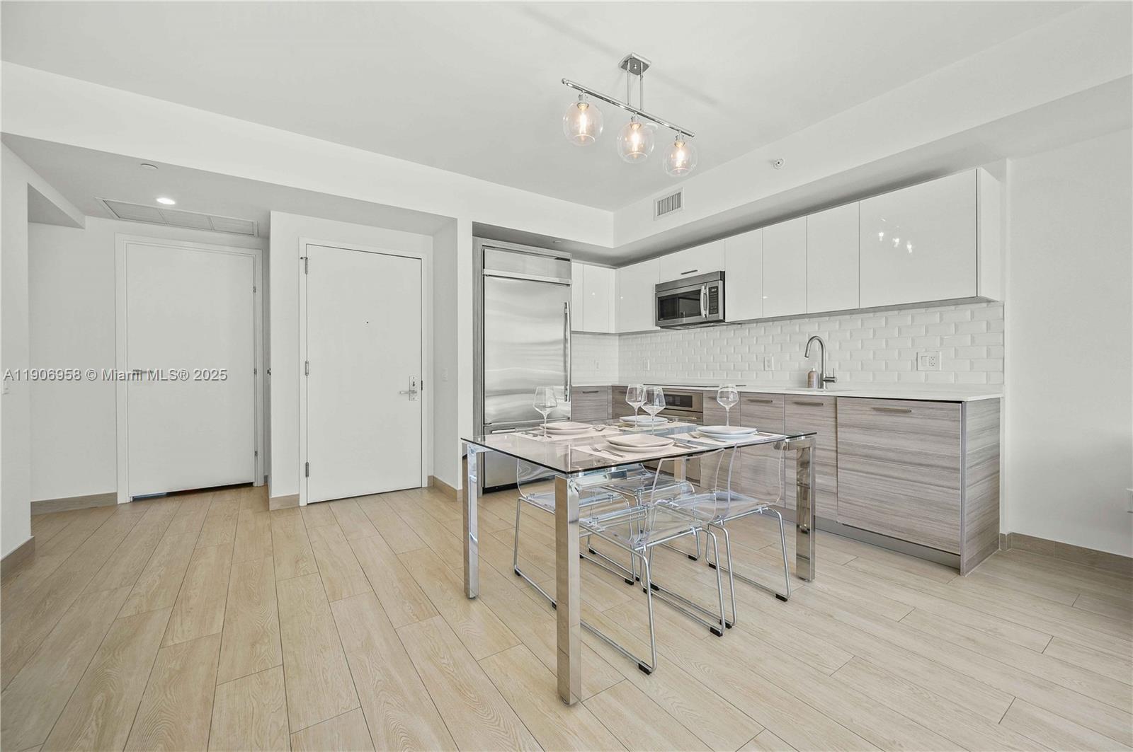 1300 Brickell Bay Drive, Unit 1603 Miami, FL 33131 - Photo 5 of 17 a kitchen with a sink appliances and cabinets