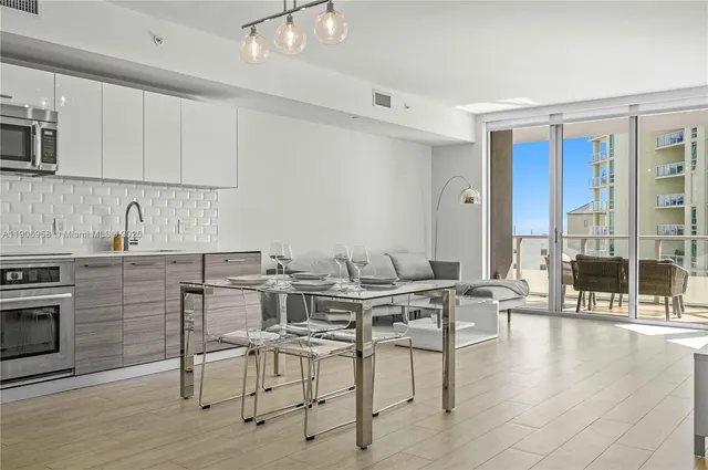 a view of kitchen with stainless steel appliances granite countertop a table and chairs in it