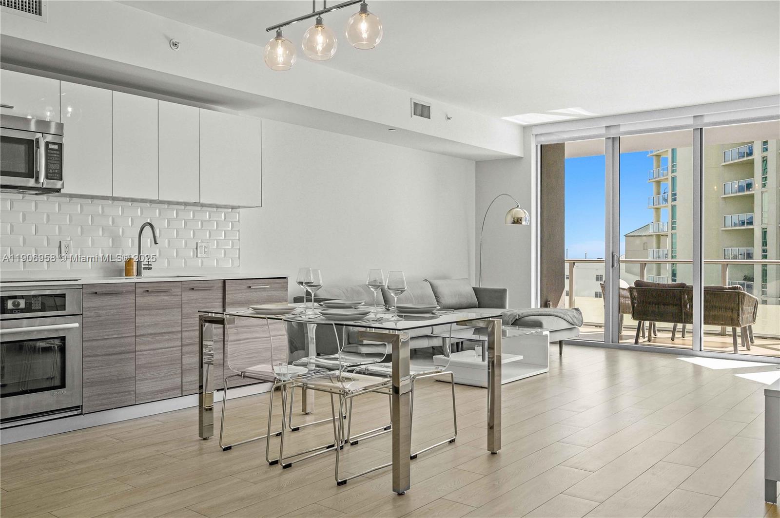 1300 Brickell Bay Drive, Unit 1603 Miami, FL 33131 - Photo 6 of 17 a view of kitchen with stainless steel appliances granite countertop a table and chairs in it