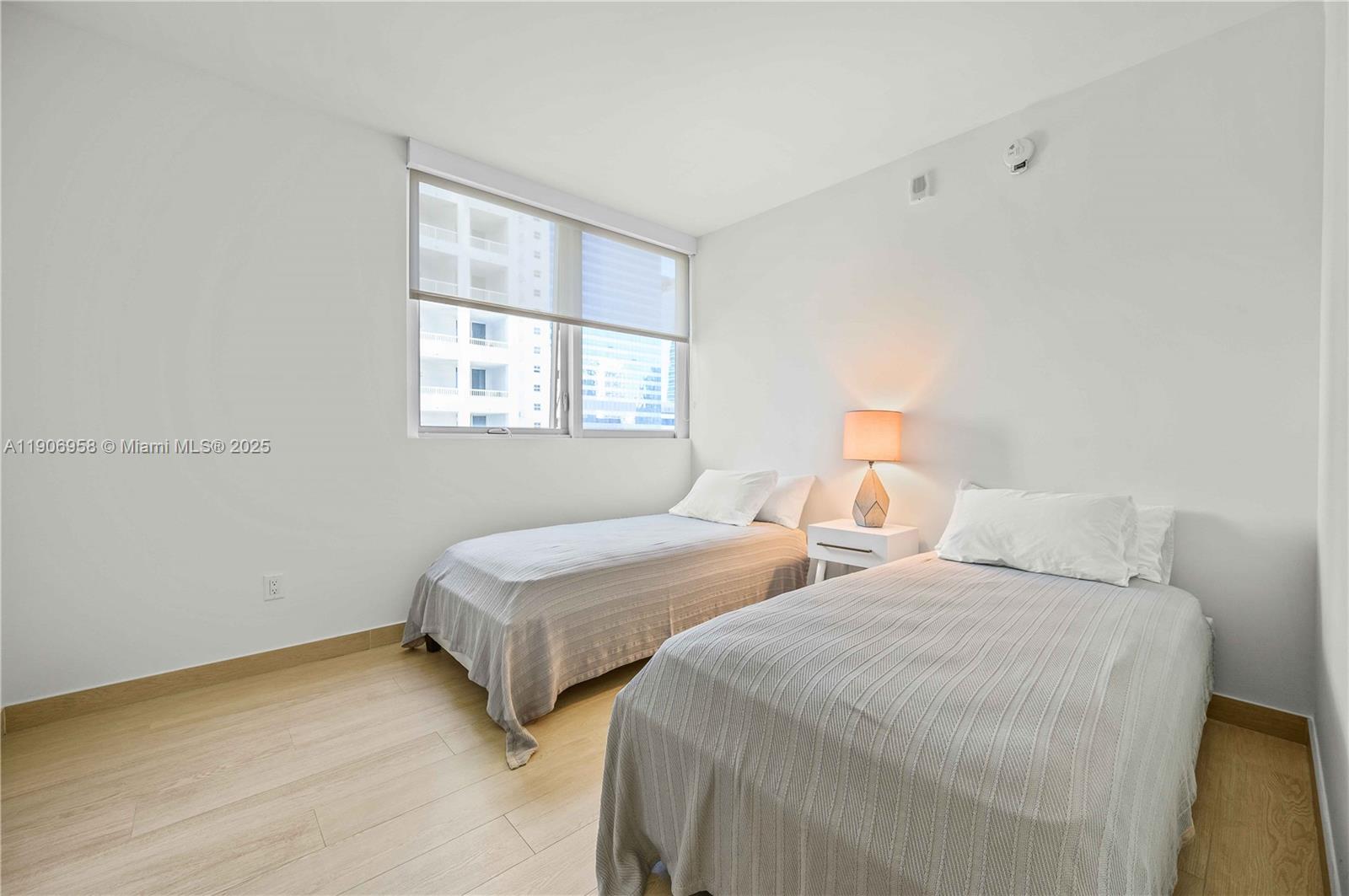 1300 Brickell Bay Drive, Unit 1603 Miami, FL 33131 - Photo 10 of 17 a bedroom with two beds and a window