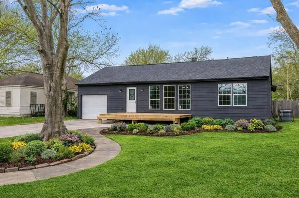 a front view of a house with a garden and plants