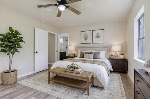 a spacious bedroom with a bed and a potted plant