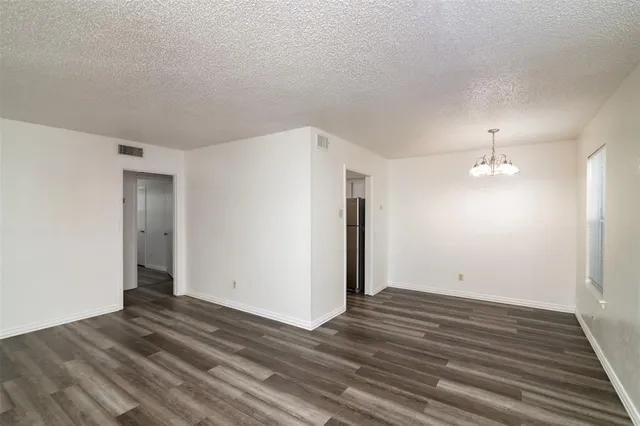a view of a room with wooden floor and a ceiling fan