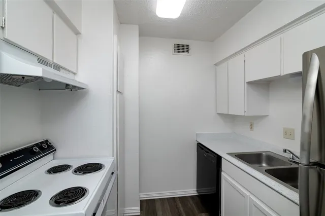 a kitchen with a sink a stove and cabinets