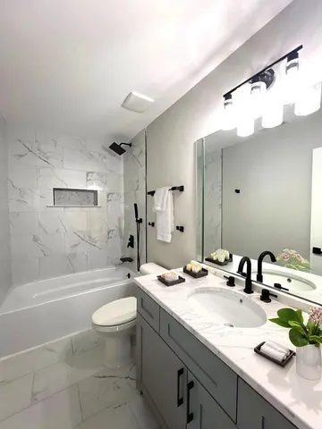 a bathroom with a sink a toilet and a mirror