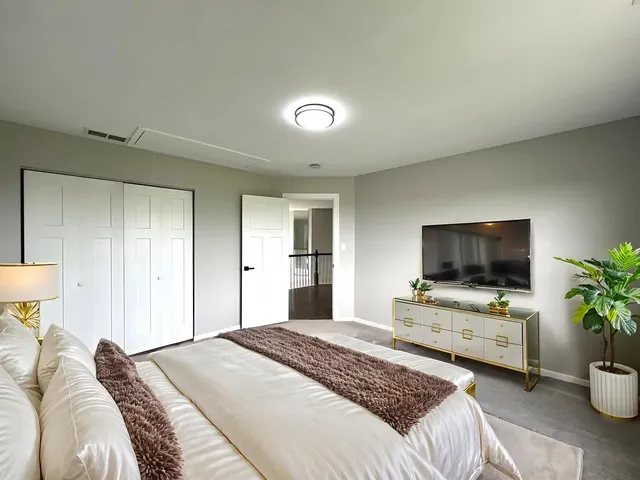 a bedroom with a bed and a potted plant